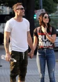 Brian and his wife Megan Fox holding hands.